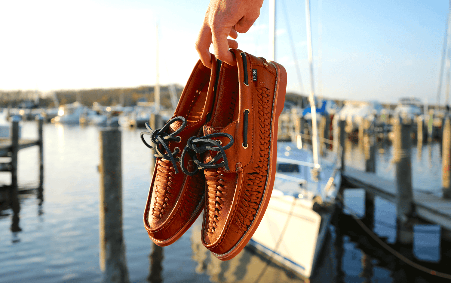 Leon leather boat shoes photographed beside a sunlit marina